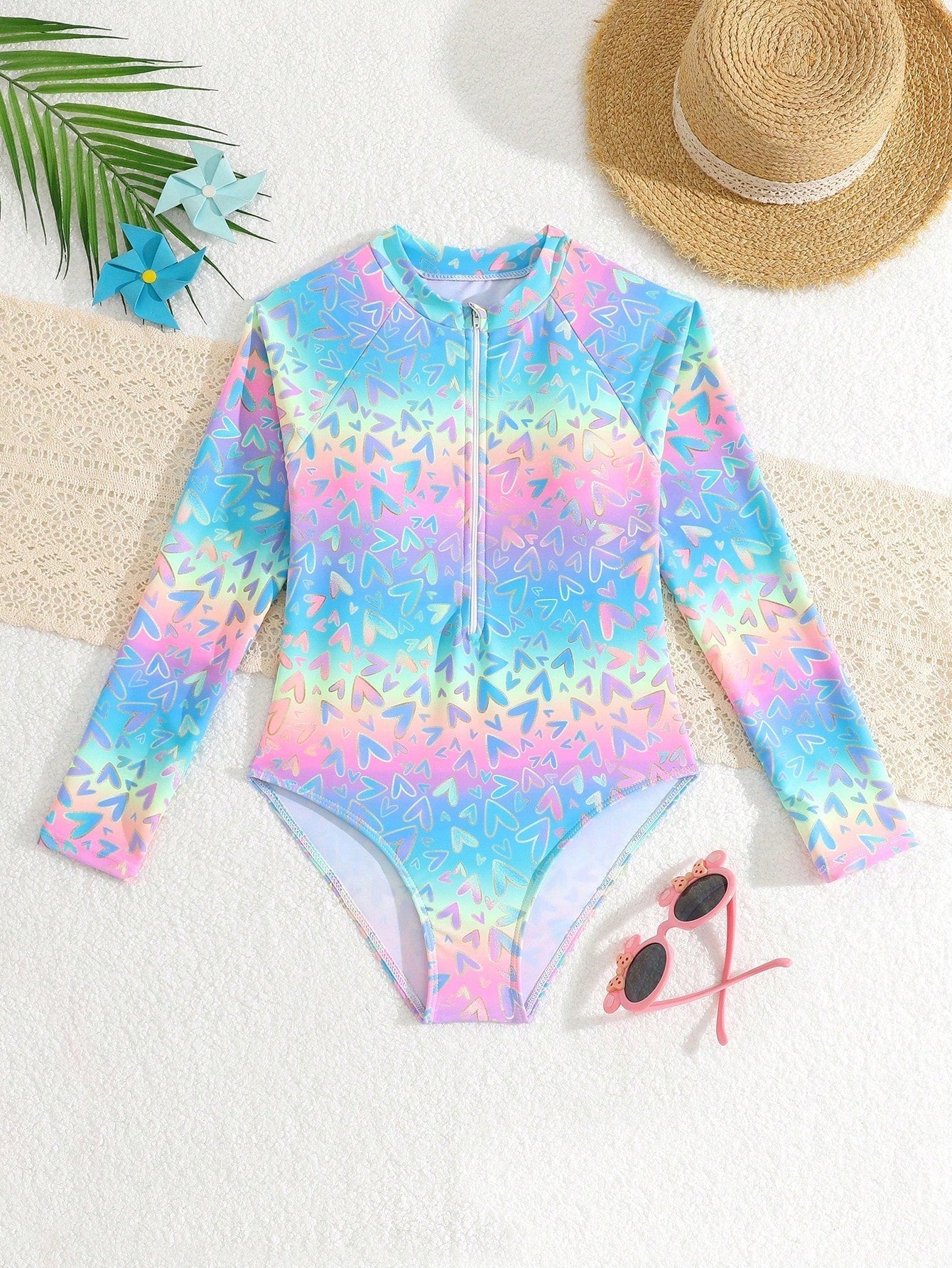 Tween girls one-piece rash guard swimsuit with long sleeves, high neck, front zipper, and ocean shell graphic print in a fitted style for beach, swimming, and vacation wear.