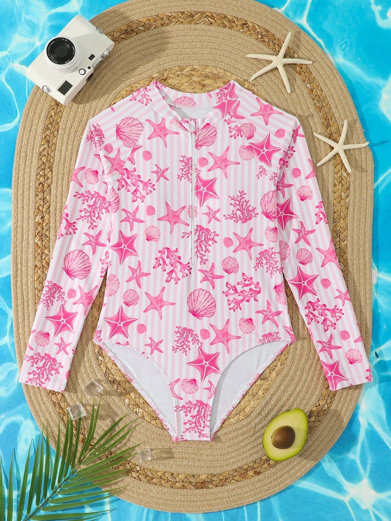 Tween girls one-piece rash guard swimsuit with long sleeves, high neck, front zipper, and ocean shell graphic print in a fitted style for beach, swimming, and vacation wear.