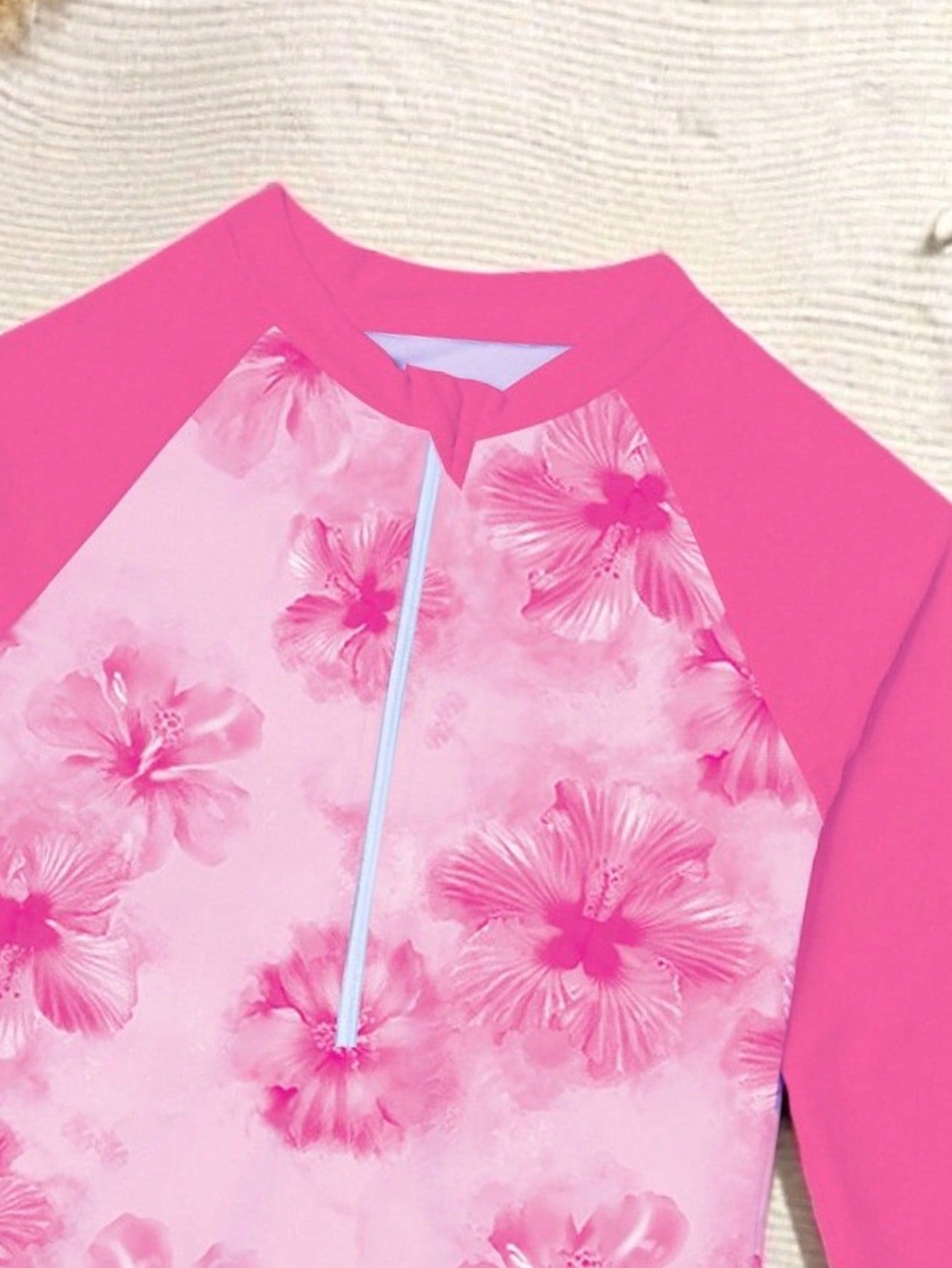 Tween girls one-piece rash guard swimsuit with long sleeves, high neck, front zipper, and ocean shell graphic print in a fitted style for beach, swimming, and vacation wear.