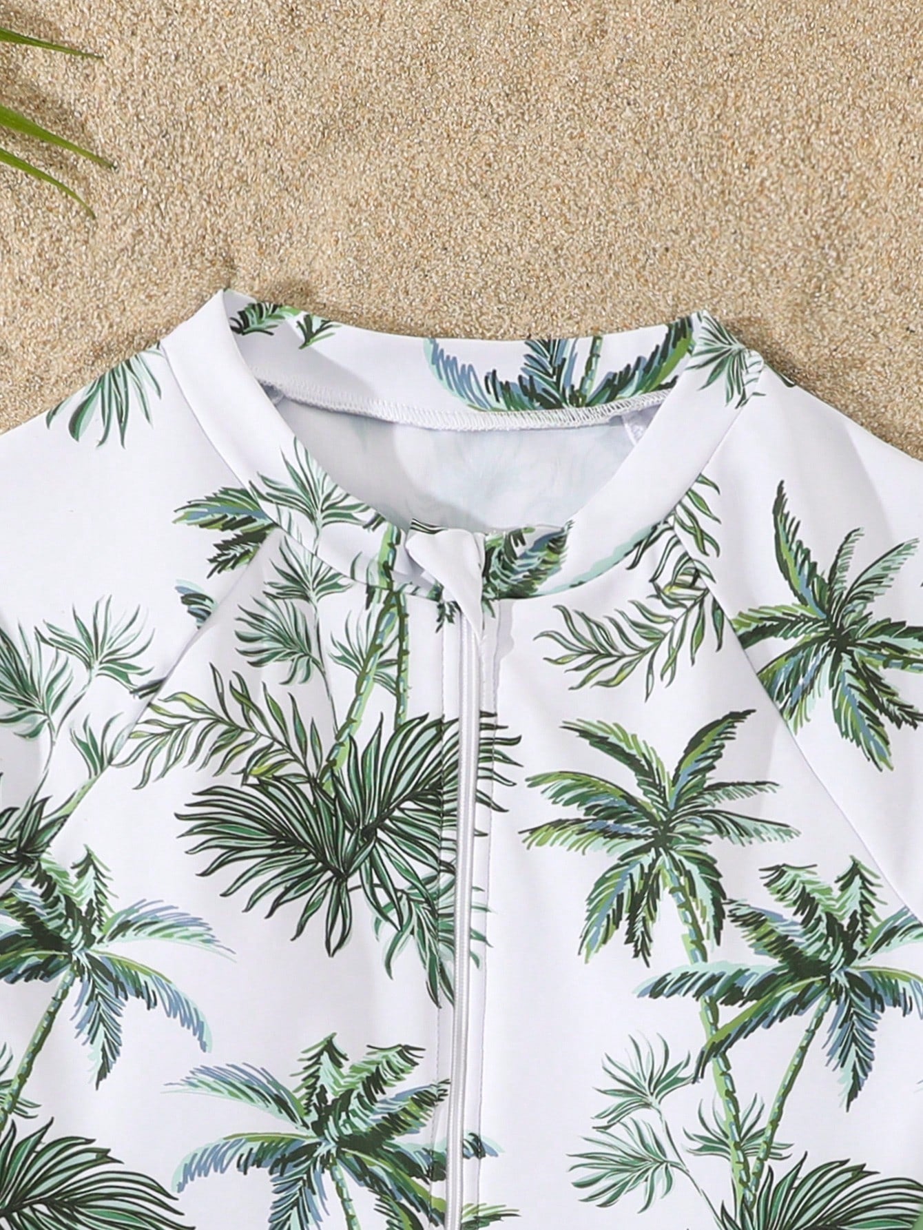 Tween girls one-piece rash guard swimsuit with long sleeves, high neck, front zipper, and ocean shell graphic print in a fitted style for beach, swimming, and vacation wear.