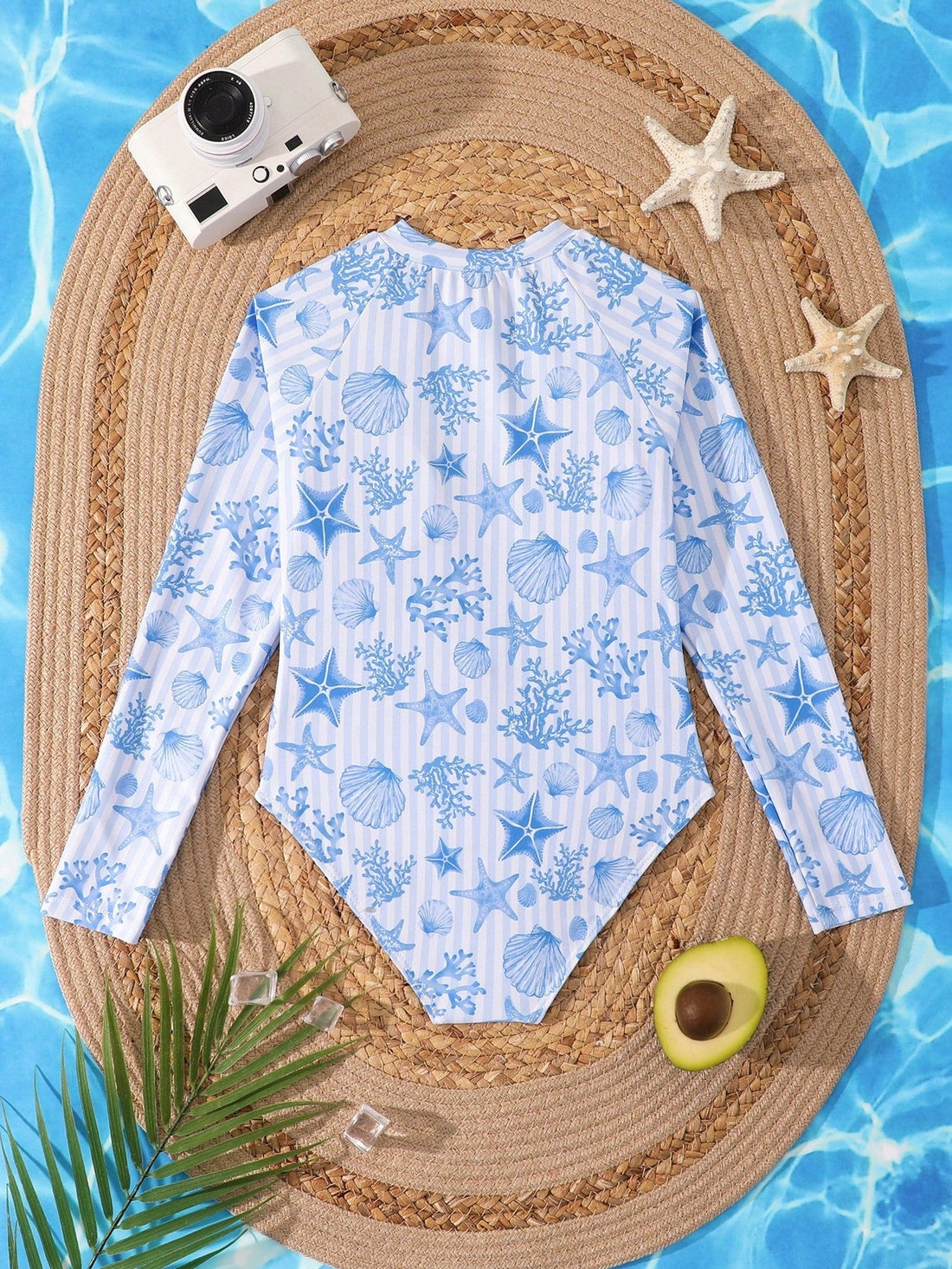 Tween girls one-piece rash guard swimsuit with long sleeves, high neck, front zipper, and ocean shell graphic print in a fitted style for beach, swimming, and vacation wear.